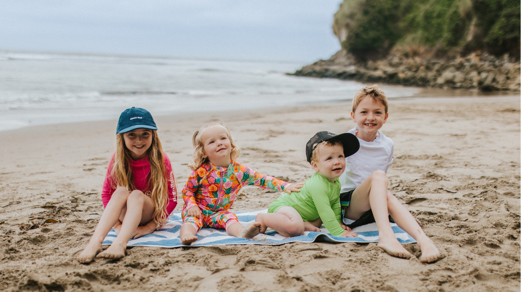 Kids wearing UPF 50+ swimwear and sun hats during a family beach vacation