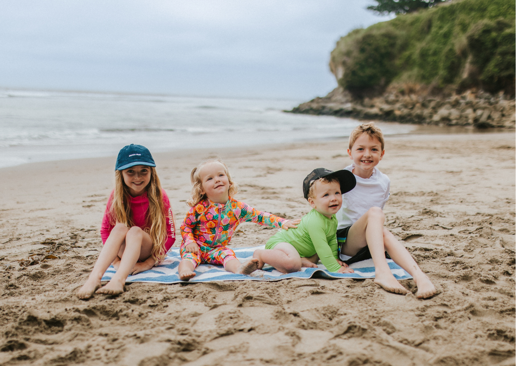 Kids wearing UPF 50+ swimwear and sun hats during a family beach vacation
