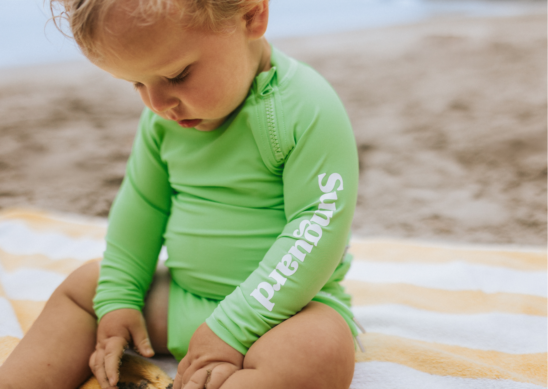 Baby boy wearing a UPF50+ rashguard swimming top